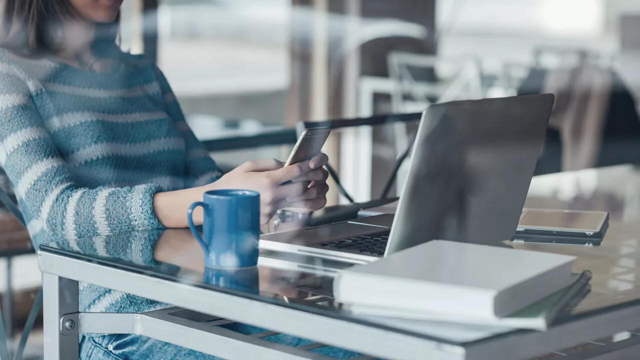 Kobieta pracująca przy laptopie na szklanym biurku