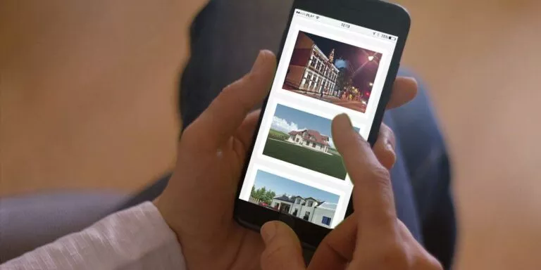 Dłoń trzymająca smartfon z przeglądaną stroną internetową
