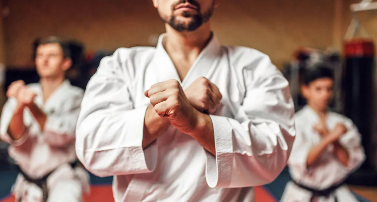 Mężczyzna w kimonie w pozycji obronnej na treningu karate