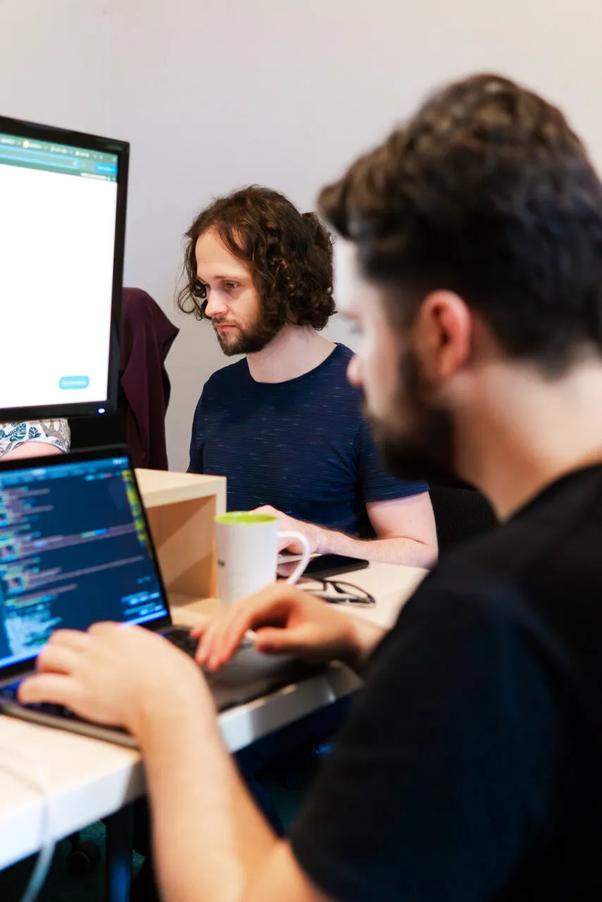 Developers working at laptops in the Brave New office